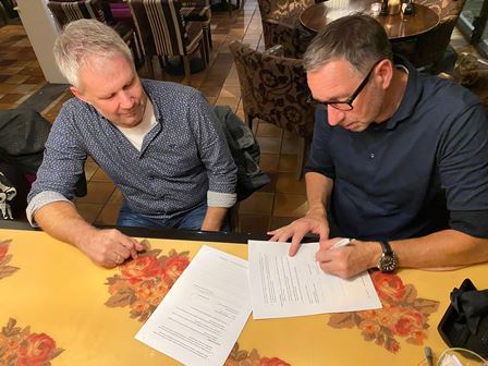Mark Bergmans ondertekent onder toeziend oog van Peter Raatjes het sponsorcontract